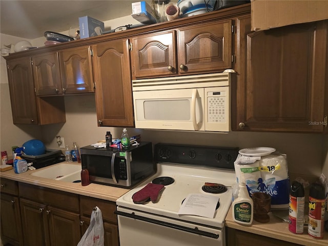 kitchen featuring dark brown cabinets and white appliances