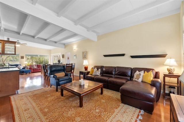 living room with lofted ceiling with beams, light hardwood / wood-style flooring, and ceiling fan