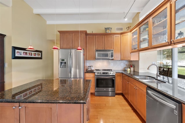 kitchen featuring decorative backsplash, stainless steel appliances, sink, decorative light fixtures, and beamed ceiling