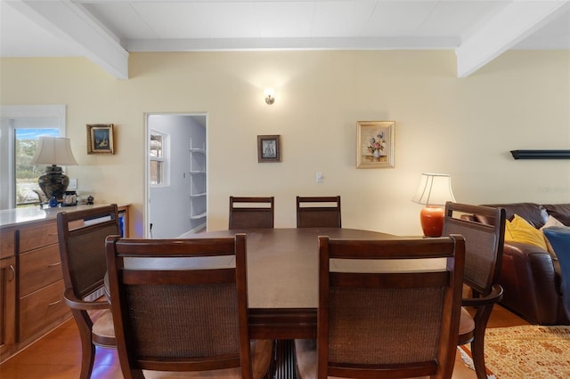 dining area featuring beamed ceiling and light tile patterned floors