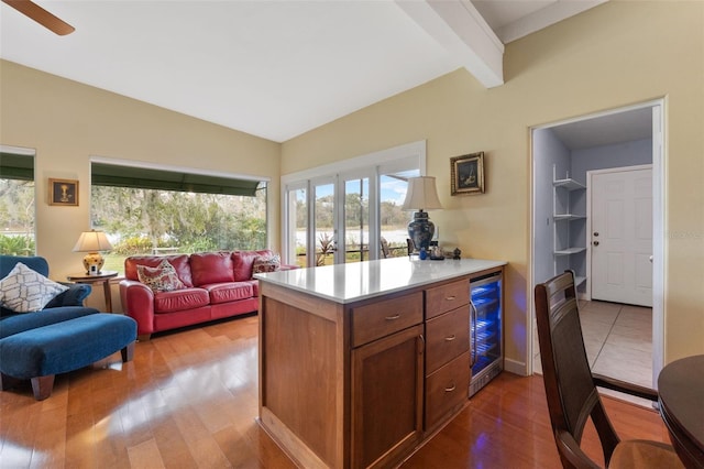 kitchen with wine cooler, light hardwood / wood-style flooring, and vaulted ceiling with beams