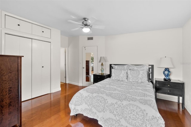 bedroom with ceiling fan, dark wood-type flooring, and a closet