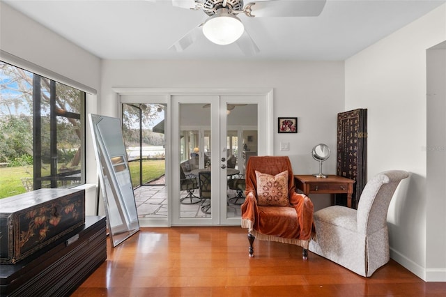 living area featuring ceiling fan, french doors, and wood-type flooring