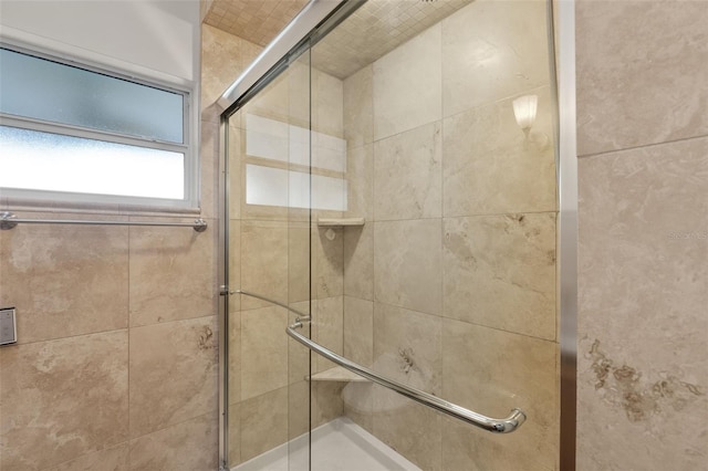 bathroom featuring a shower with door