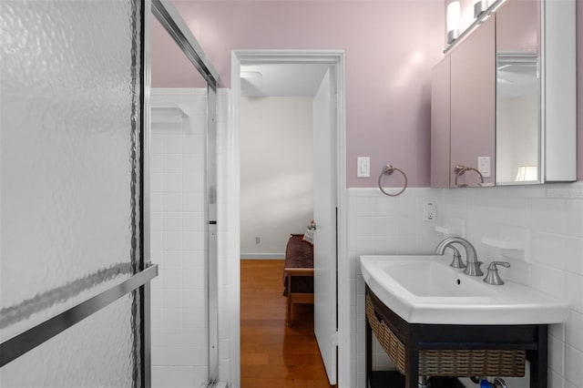 bathroom featuring decorative backsplash, sink, wood-type flooring, and tile walls