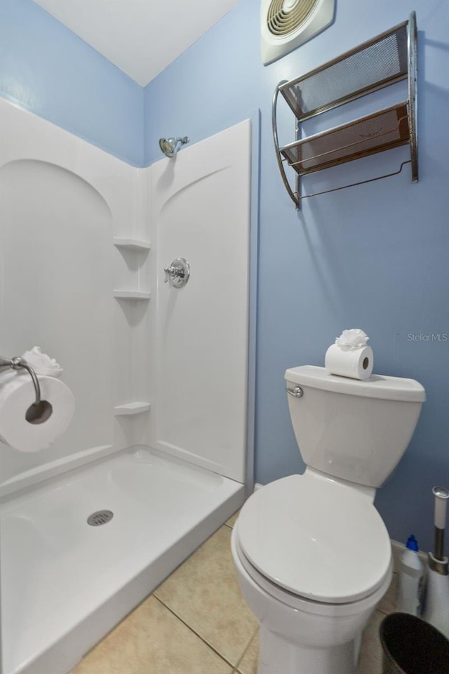 bathroom featuring toilet, tile patterned flooring, and walk in shower