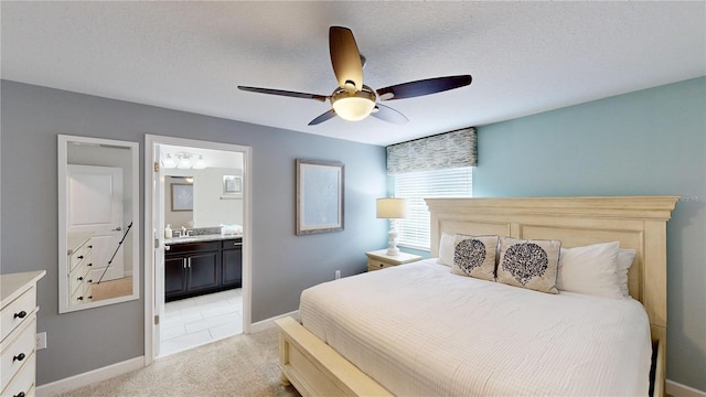 carpeted bedroom with ceiling fan, a textured ceiling, and ensuite bath