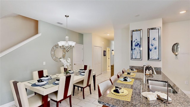 dining area with light tile patterned floors, an inviting chandelier, and sink