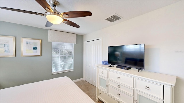 bedroom featuring ceiling fan, light colored carpet, and a closet