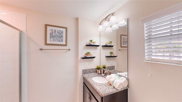 bathroom featuring a textured ceiling, vanity, and walk in shower