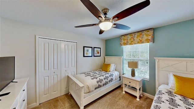 bedroom featuring ceiling fan, a closet, and light colored carpet