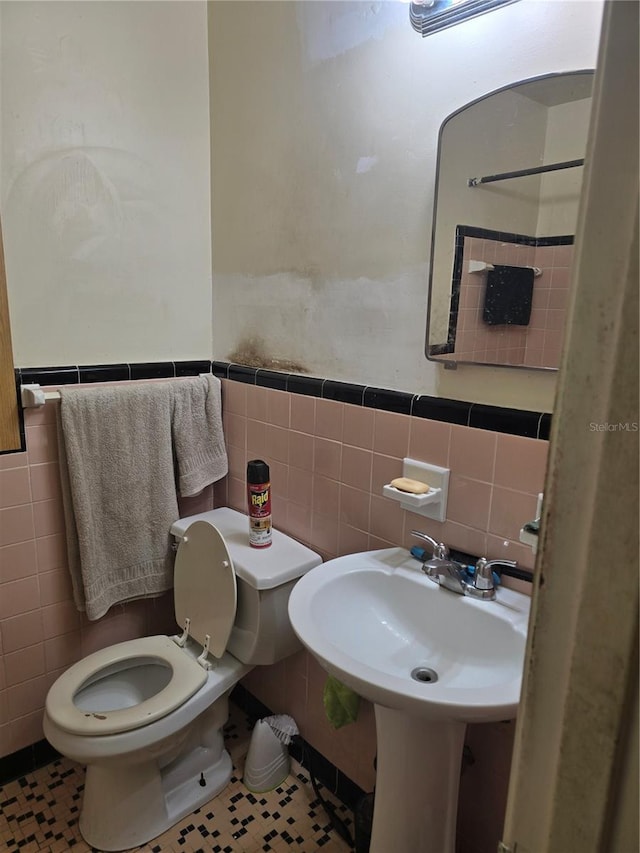 bathroom featuring tile patterned floors, tile walls, and toilet