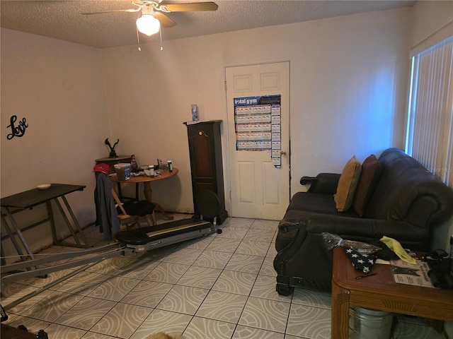 living room featuring ceiling fan and a textured ceiling