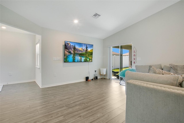 living room featuring light hardwood / wood-style flooring and vaulted ceiling