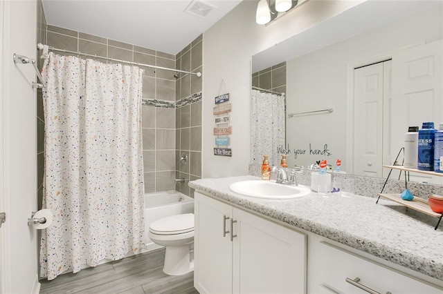 full bathroom with hardwood / wood-style floors, vanity, toilet, and shower / tub combo