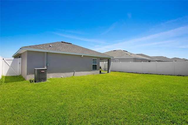 back of property featuring a lawn and central AC