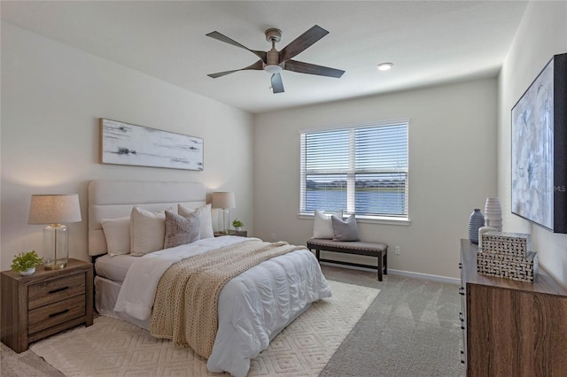 bedroom featuring light carpet, ceiling fan, and baseboards