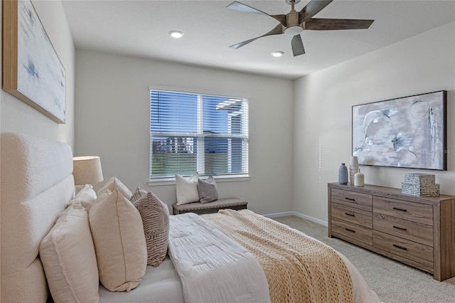 bedroom featuring light carpet, a ceiling fan, and baseboards