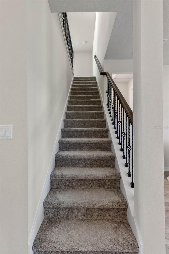 stairs featuring carpet and baseboards