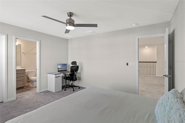 bedroom featuring baseboards, ceiling fan, ensuite bath, and light colored carpet