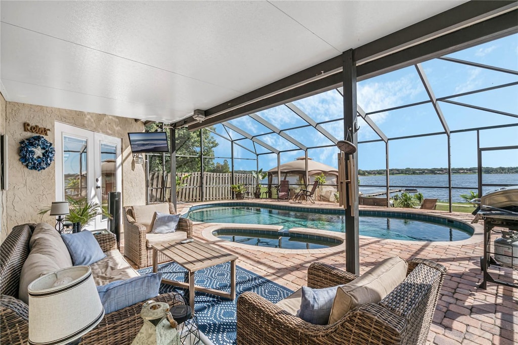 view of pool with french doors, a lanai, an outdoor living space, an in ground hot tub, and a patio