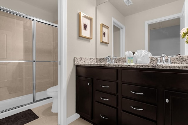 bathroom featuring tile patterned floors, vanity, toilet, and a shower with shower door