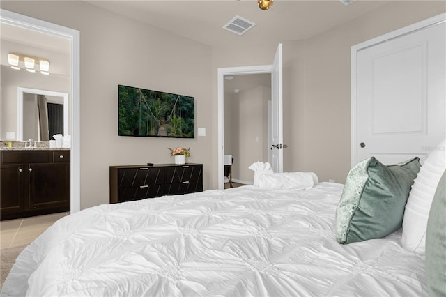 tiled bedroom with ensuite bathroom and sink