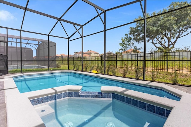 view of swimming pool featuring glass enclosure and an in ground hot tub