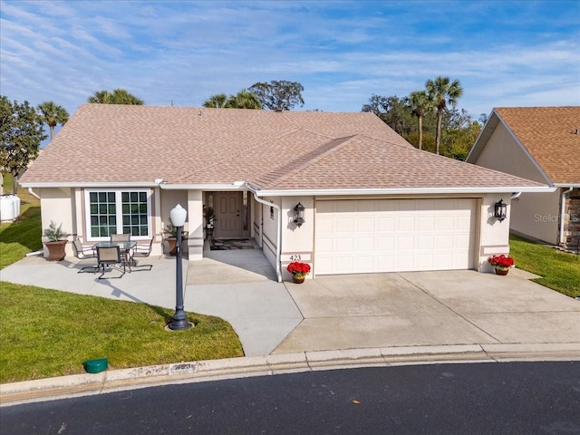 ranch-style home featuring a front lawn, a garage, and a patio