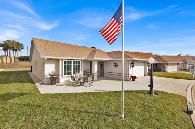 exterior space featuring a garage, a patio area, and a yard