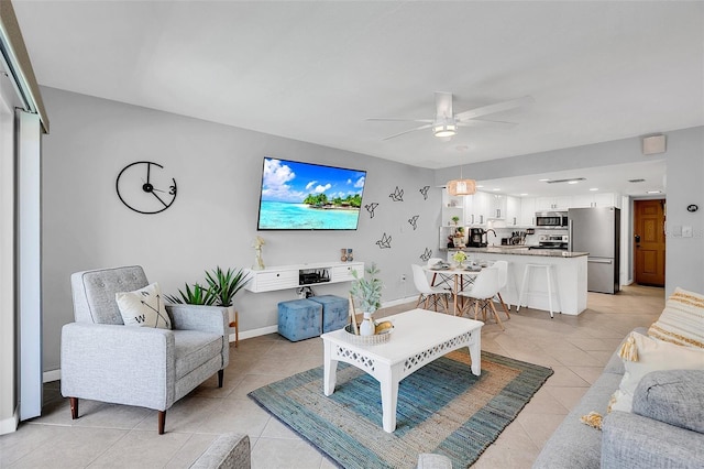 living room with ceiling fan, sink, and light tile patterned flooring