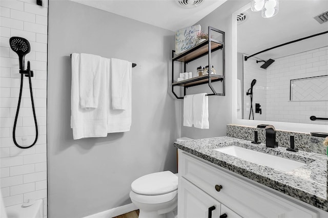 bathroom with vanity, toilet, and tiled shower