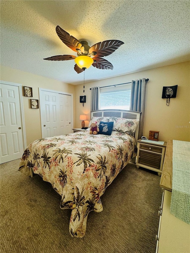 bedroom featuring ceiling fan, a closet, a textured ceiling, and dark colored carpet