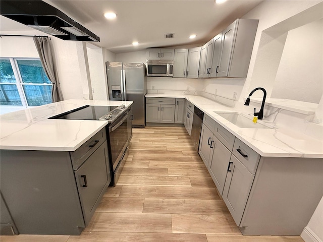 kitchen featuring gray cabinetry, light stone counters, sink, and appliances with stainless steel finishes