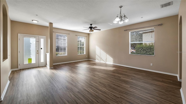 interior space featuring baseboards, arched walkways, and dark wood-style floors