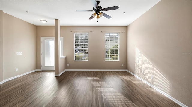 spare room with a ceiling fan, wood finished floors, and baseboards