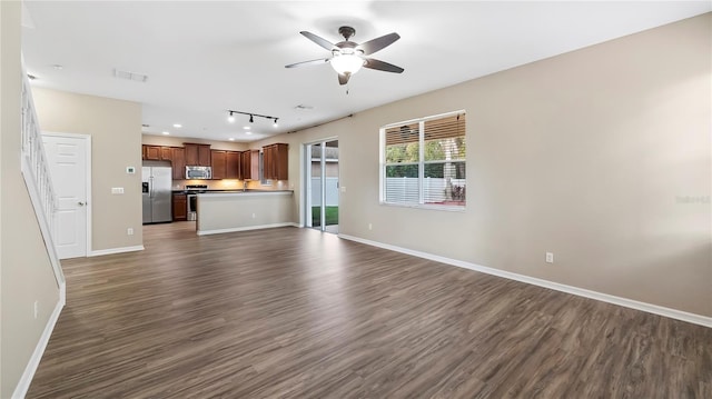 unfurnished living room with visible vents, dark wood-style floors, baseboards, and ceiling fan