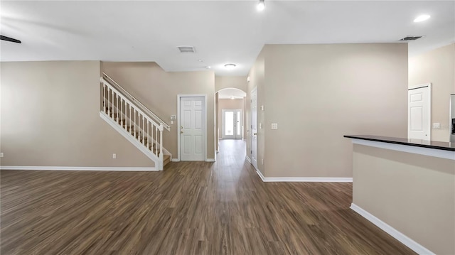 foyer with stairs, dark wood-type flooring, baseboards, and visible vents