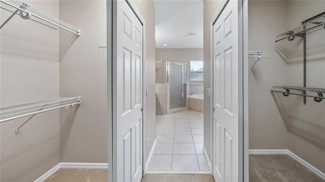 walk in closet with light tile patterned floors