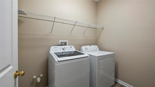 laundry area with baseboards, laundry area, and washer and clothes dryer