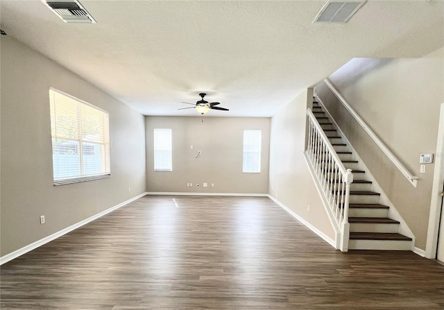 unfurnished living room featuring visible vents, a textured ceiling, ceiling fan, and dark wood-style flooring