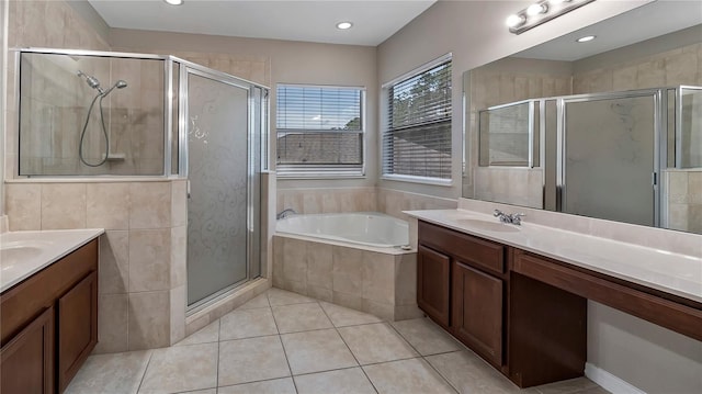 bathroom featuring tile patterned floors, two vanities, a stall shower, a sink, and a bath