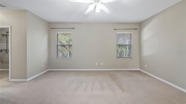 carpeted empty room featuring baseboards and ceiling fan