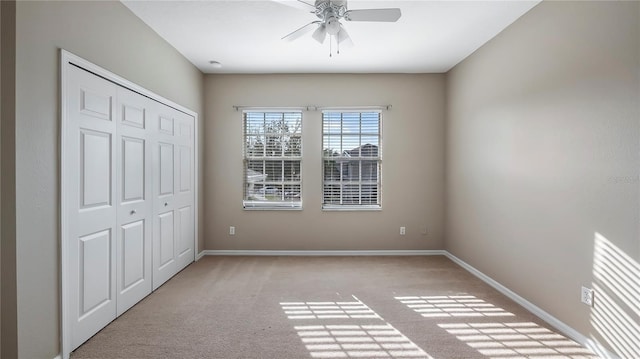 unfurnished bedroom featuring a closet, a ceiling fan, baseboards, and carpet floors