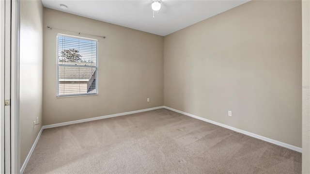 carpeted empty room featuring baseboards