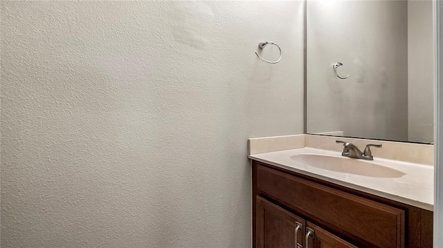 bathroom featuring vanity and a textured wall