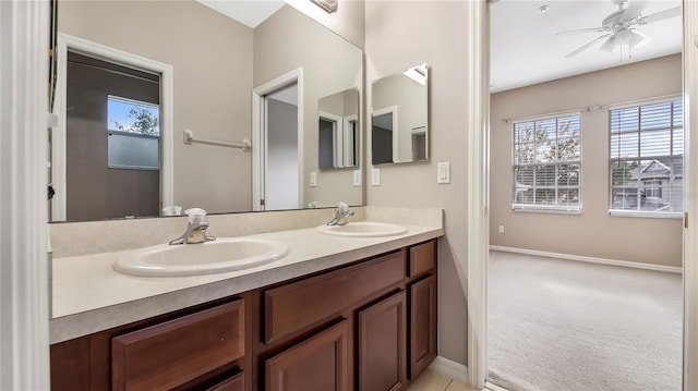 bathroom featuring double vanity, baseboards, a ceiling fan, and a sink