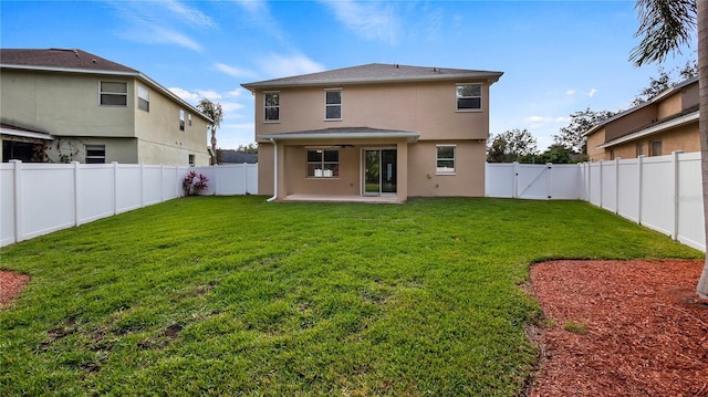 back of house featuring a yard, a patio, a fenced backyard, and stucco siding