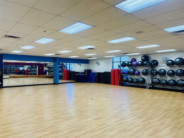 exercise room featuring visible vents, a paneled ceiling, and wood finished floors