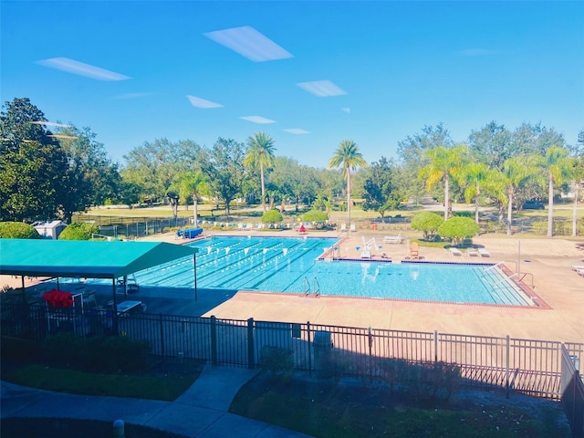 pool with a patio and fence